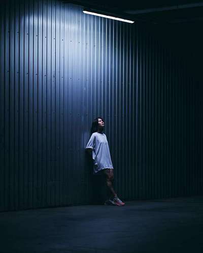 Mulher jovem posando em frente a uma parede iluminada à noite