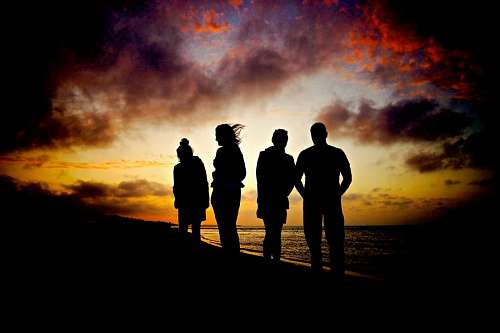 quatro Pessoas na praia ao pôr do sol