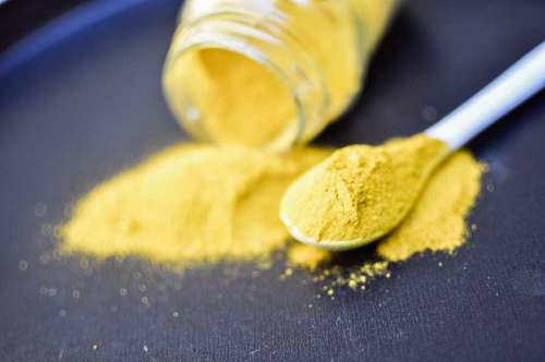 Pilha de curcuma em pó isolado no fundo preto