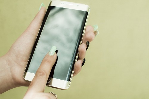 polegada Mãos de mulher com smartphone curvo