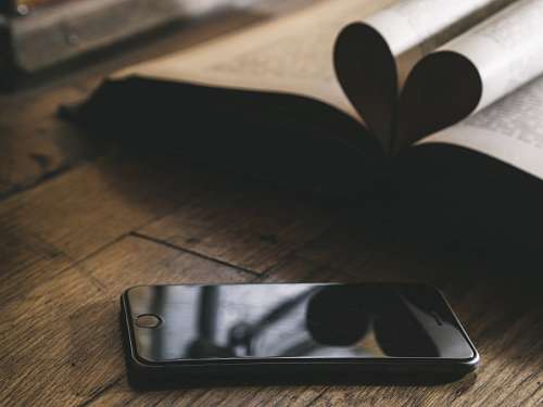 Smartphone ao lado de um livro