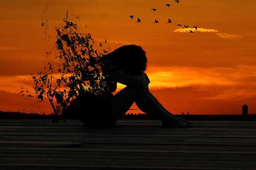 chorando Silhueta de mulher quebrada no pôr do sol