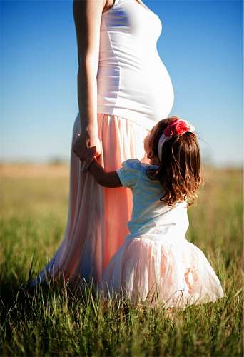 Mãe grávida com a filha ao ar livre