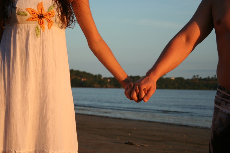 casal, amor, fora, praia, segurando as mãos, homem, mulher, vista traseira, dia, verão, férias, vestido, flor, alegria, felicidade,