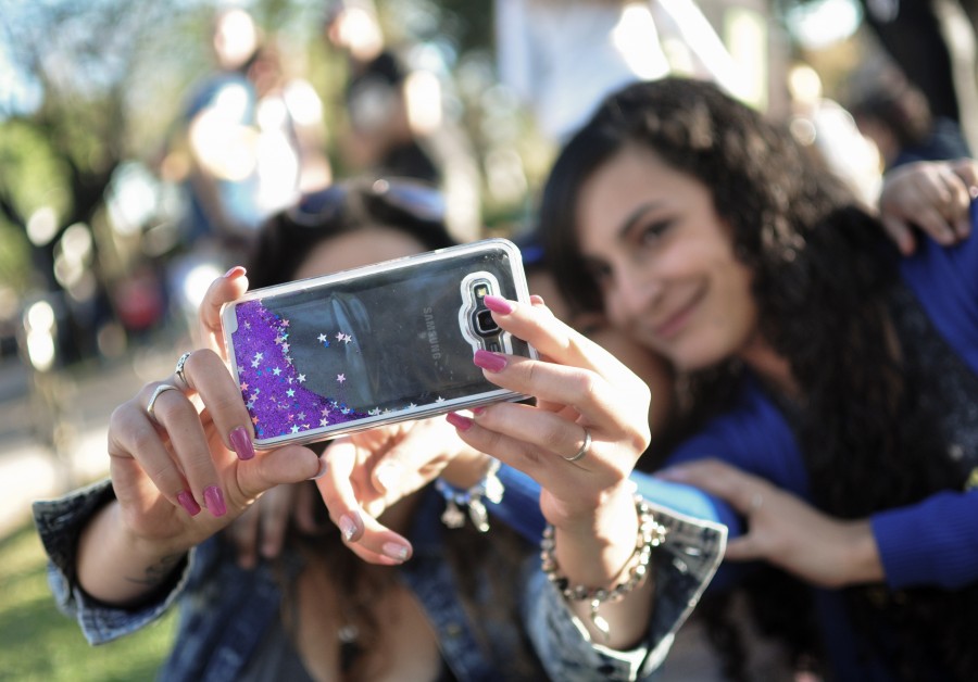 mulheres, jovens, 20-25 anos, amigos, companheiros, risos, felicidade, ao ar livre, telefone celular, smartphone, móvel, tecnologia, câmera, foto, selfie, grupo, brilho, mãos mãos, unhas, femininas, violeta, borrão, grupo de pessoas, fotografia